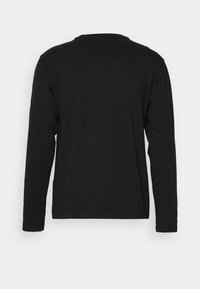 Schwarzes Langarm-T-Shirt aus weicher Baumwolle. Verfügt über einen Rundhalsausschnitt und keine sichtbaren Grafiken oder Muster. Einfaches, eng anliegendes Design.