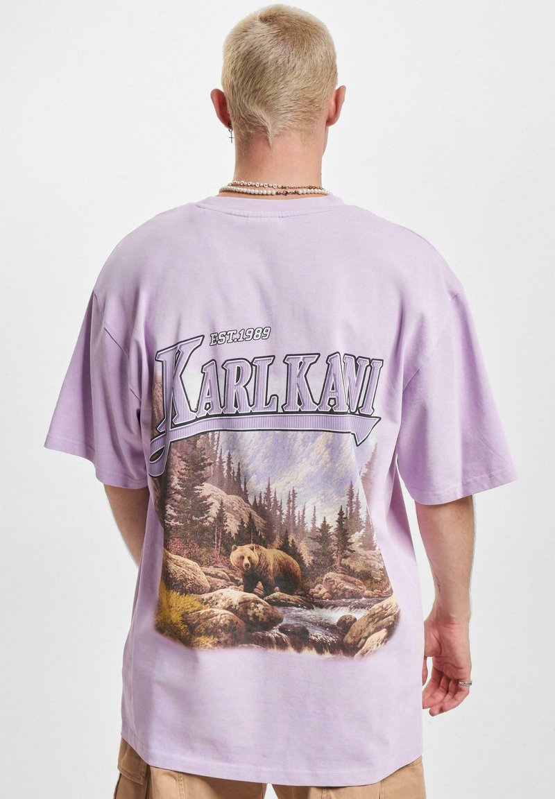 Purple cotton t-shirt featuring a large bear graphic with trees and rocks on the back, "Karl Kani" text above, established 1989.