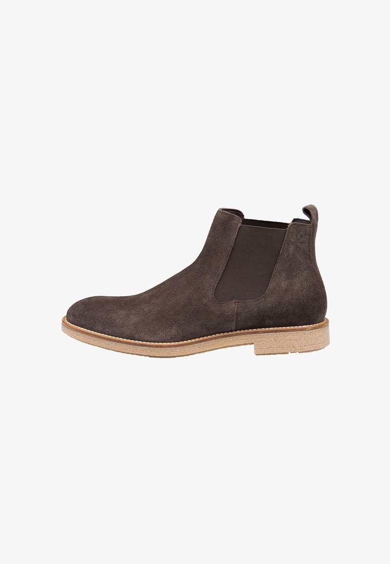 Mørkebrun suede Chelsea støvle med elastiske sidepaneler, rund tå og tekstureret gummisål. Syede detaljer langs den øverste kant.