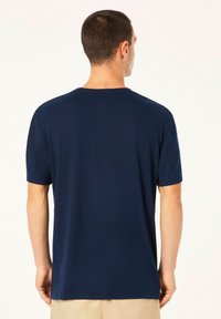 Navy blue short-sleeve t-shirt made of soft fabric, featuring a crew neck and a simple, clean design, visible stitching on sleeves and hem.