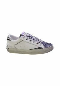 Zapatilla blanca con una punta plateada texturizada y brillante, detalles de estampado animal en negro y blanco en el talón, y cordones grises con marca.