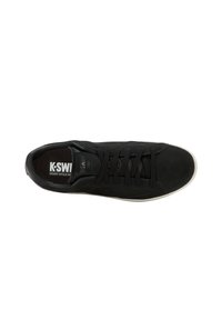 Musta mokkanahka K-Swiss matalavartinen tennari mustilla nauhoilla, valkoisella pohjalla ja brändätyllä sisäpohjalla, jossa lukee "COURT STYLE SINCE 1966".