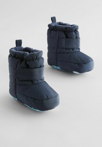 Marineblå polstrede vinterstøvler med velcrolukning, rund tå og blødt tekstureret for. Rutsjesikker lyseblå ydersål.