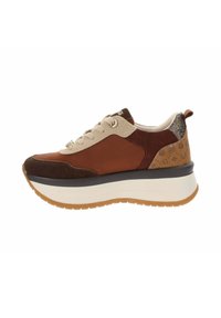 Zapatilla marrón y beige con una mezcla de ante y cuero. Presenta una suela de plataforma blanca y detalles metálicos. Detalles laterales con patrones.
