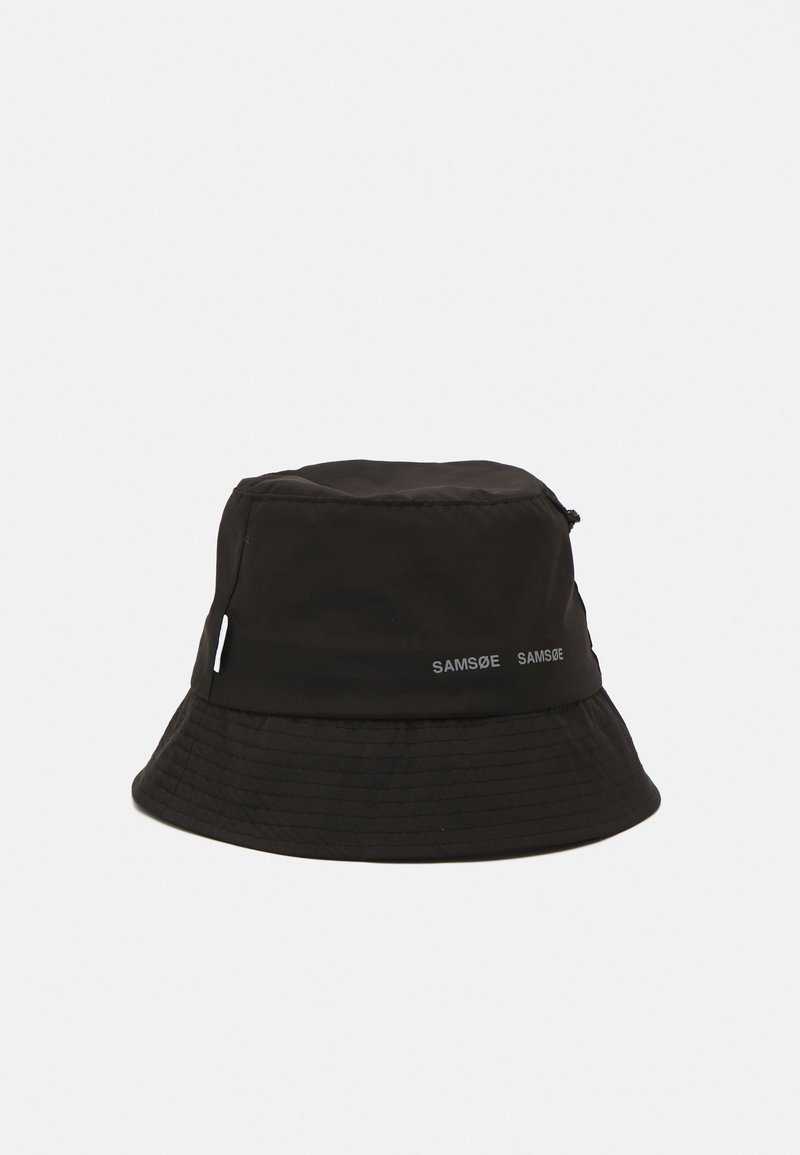 Zwarte bucket hat gemaakt van lichtgewicht stof, met een ronde kroon en brede rand. Merkennaam "SAMSØE" in het wit gedrukt aan de zijkant.