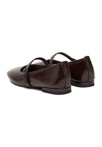 Zapatos planos de cuero marrón con punta afilada, dos correas ajustables y un tacón pequeño. Textura suave con acabado brillante.