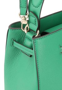 Groene leren handtas met een gestructureerde afwerking, voorzien van gouden hardware, contrasterende zwarte stiksels en een afneembare schouderband.