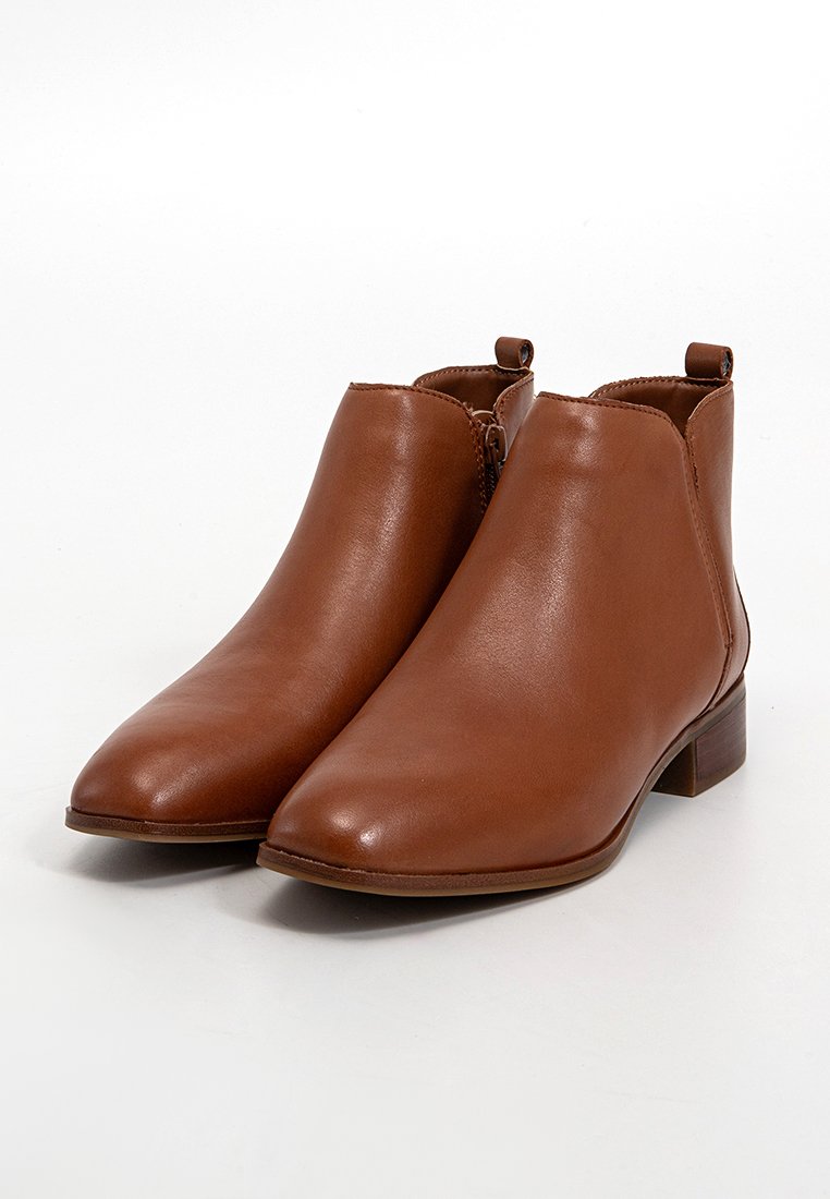 Bottines en cuir marron avec un design à bout pointu, texture lisse, petit talon empilé et fermeture éclair sur le côté.