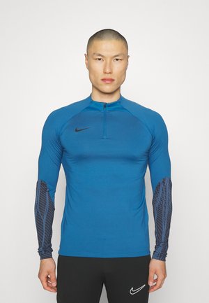 Blauw sportief langarmshirt met een kwart rits, voorzien van zwarte patroondetails op de mouwen en een subtiele Nike-logo op de borst.