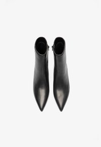 Zwarte leren enkelbootjes met een spitse neus en een gladde textuur, voorzien van een ritssluiting aan de achterkant voor gemakkelijk aan- en uittrekken.