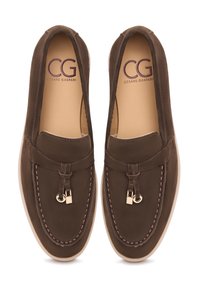 Bruine nubuck loafers met een gestikt ontwerp, gouden accenten en een gladde zool met minimale textuur. Het opschrift luidt "CG."