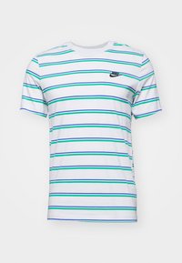 Bílý bavlněný tričko s vertikálními zelenými a modrými pruhy. Má černé logo Nike na hrudi. Kulatý výstřih. Krátké rukávy.