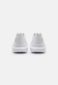 Chaussures de sport blanches avec une tige en maille, un bout arrondi et une semelle texturée. Présentent un logo de marque discret à l'arrière et un intermédiaire rembourré.