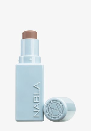 NABLA crème stick in lichtblauwe verpakking met een bruine sticktop. Bevat een verhoogd logo en een ronde dop met decoratieve accenten.