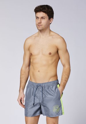 Graue Badehosen mit strukturierter Oberfläche, ausgestattet mit einem neongrünen Seitenpanel und einem Kordelzugbund. Enthält ein bedrucktes Logo auf der Vorderseite.