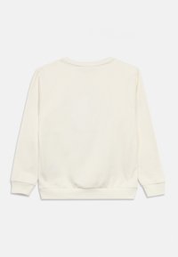 Φόρμα σε ανοιχτό κρεμ χρώμα με μακριά μανίκια, ριμπ μανσέτες και στρίφωμα· απαλό ύφασμα και απλό σχεδιασμό στο πίσω μέρος χωρίς εμφανή λογότυπα ή σχέδια.