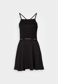 Svart ärmlös klänning med en figursydd överdel och utsvängd kjol. Har tunna remmar och ett elastiskt midjeband med "Calvin Klein Jeans"-logotyp.