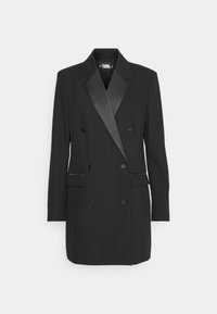 Svart dubbelknäppt blazer med satinpiqué på lapellerna, två framfickor med klaff, sex knappar och långa ärmar på en vit bakgrund.