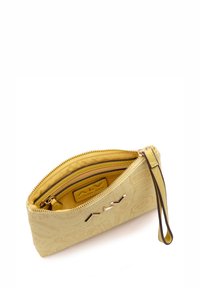 Pochette gialla con zip realizzata in materiale sintetico, caratterizzata da un delicato motivo in rilievo e da un manico in pelle marrone. All'interno, ha una morbida fodera gialla.