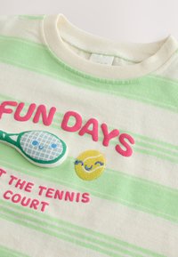 Cotton t-shirt with cream and green stripes, featuring pink embroidered text "FUN DAYS," a tennis racquet, and a smiling tennis ball.