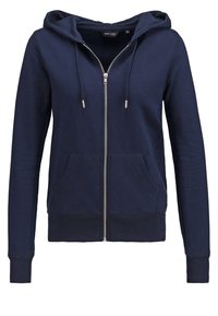 Sweat à capuche bleu marine zippé avec cordon de serrage à la capuche, poches avant et poignets et bas côtelés, présenté sur fond blanc.