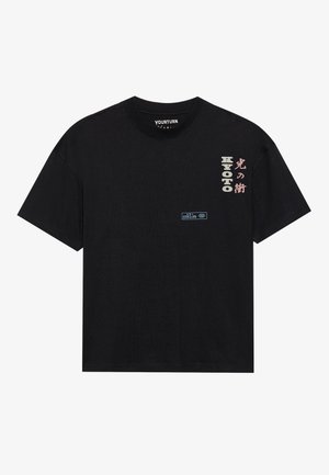 Black cotton t-shirt with short sleeves, featuring multi-colored text designs in Japanese and English; a small blue label on the front.