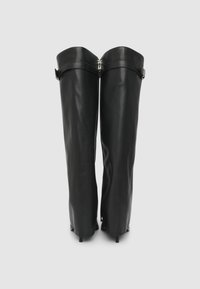 Stivali in pelle nera al ginocchio con un design elegante e aderente; presentano cinghie regolabili e una zip in metallo lucido per la chiusura.