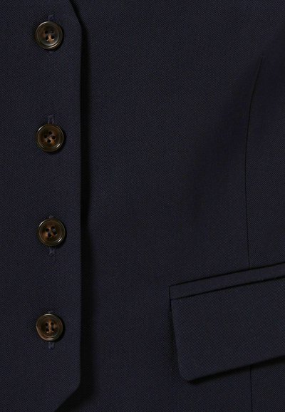 Ripresa ravvicinata di un tessuto blu scuro con bottoni prominenti e una tasca laterale, che mette in risalto un dettaglio di un indumento su misura.