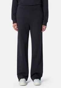 Pantalones de chándal azul marino con un corte relajado, hechos de tejido suave. Presentan una cinturilla elástica y puños acanalados. Diseño minimalista sin patrones.