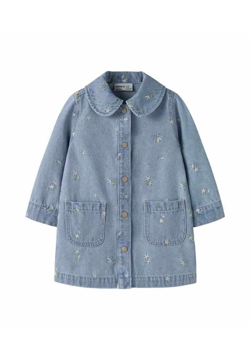 Denimjakke i lys blå farge, med stor krage, frontknapper, to påsydde lommer og broderte blomsterdekorasjoner over hele jakken.