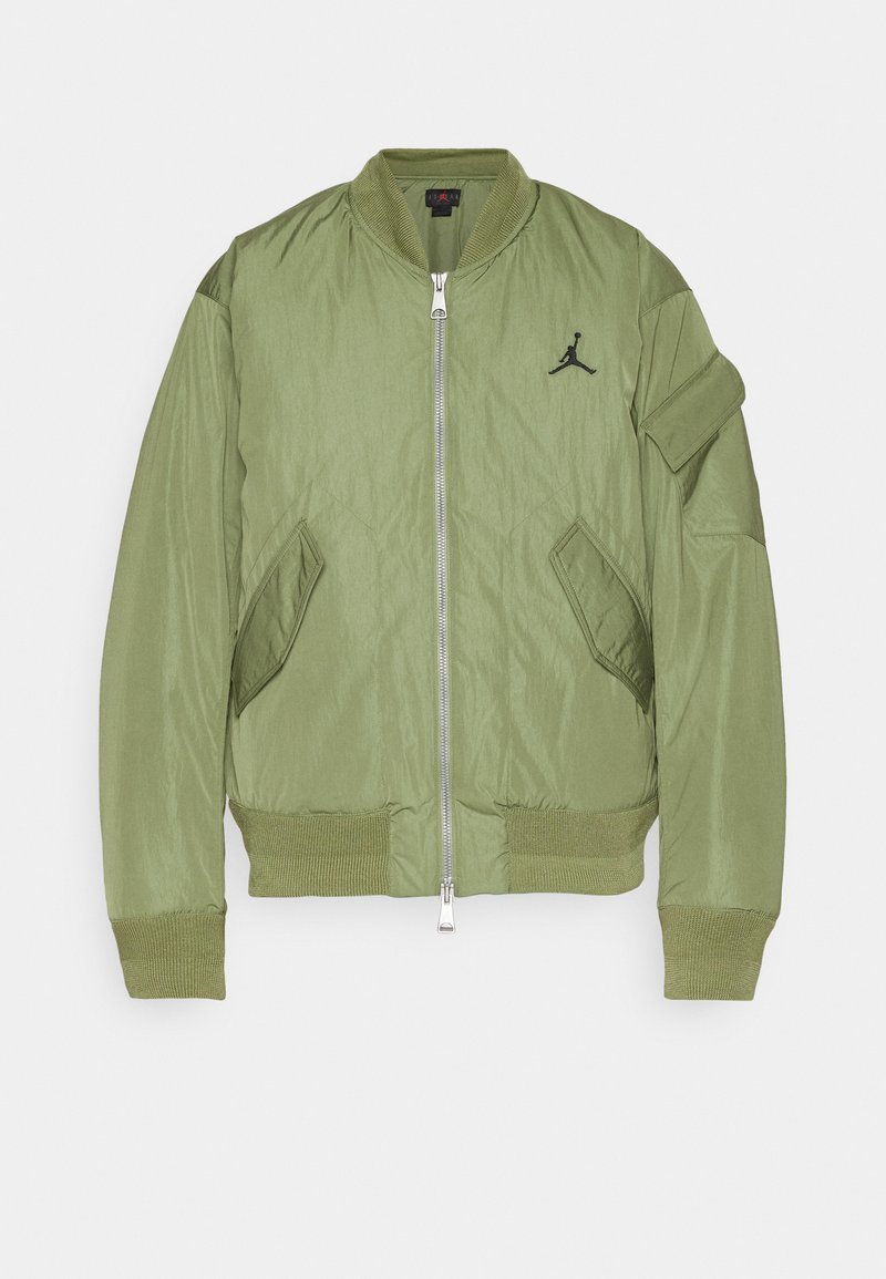 Chaqueta bomber verde oliva hecha de tela ligera, con cierre frontal de cremallera, puños acanalados, bolsillos laterales y un logo negro en el pecho.