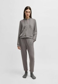 Gray zip-up hoodie with drawstrings and matching tapered sweatpants, both in a smooth, soft fabric, featuring side accents and ribbed cuffs.