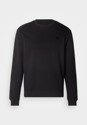 Czarny sweter z okrągłym dekoltem, wykonany z miękkiego materiału, z prążkowanymi mankietami i dołem, z małą czarną naszywką logo na klatce piersiowej.