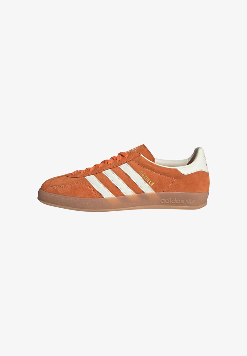 Orange suede sneaker with white leather accents, featuring three white stripes and a textured gum rubber sole. Embossed branding on the side.