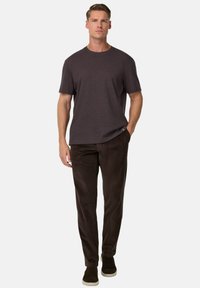 Trumpas rankovėmis tamsiai pilkas marškinėliai derinami su tamsiai rudos spalvos aksominiais kelnėmis ir ruda šlepetėmis, pasižymi laisvu siluetu ir lygia tekstūra.