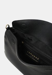 Borsa a tracolla in pelle nera con superficie testurizzata, dotata di un comparto con zip all'interno, marchio dorato e interno liscio.