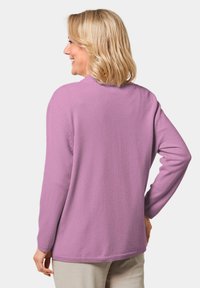 Lila, weicher Pullover mit langen Ärmeln, klassischem Rundhalsausschnitt und gerippten Bündchen. Die Rückseite ist glatt, mit einer lockeren Passform und minimaler Naht.