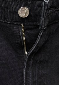 Pantalon en denim noir avec une fermeture éclair, un bouton en métal et des détails de couture visibles. Le tissu a un aspect légèrement texturé.