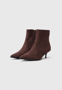Botas de cano baixo em camurça castanha com bico fino e um salto pequeno de 3 polegadas, apresentando um fecho lateral e uma textura suave.