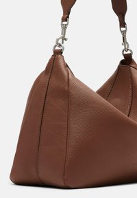 Brown leather handbag features a triangular shape with textured surface and silver-tone hardware for adjustable strap attachment.