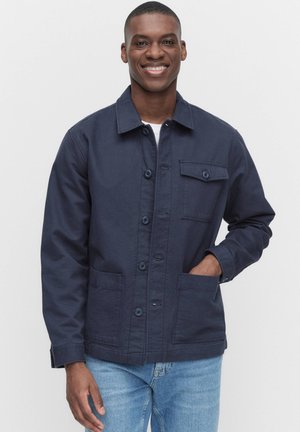 Marineblaue Jacke mit Knopfleiste, zwei Vordertaschen und einer Brusttasche. Hergestellt aus Baumwolle mit glatter Textur.