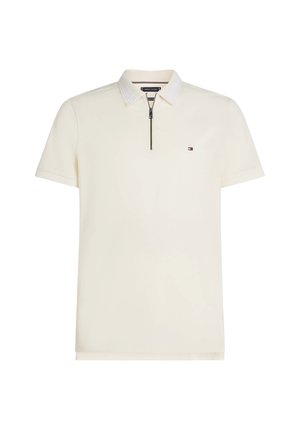 Polo à manches courtes couleur crème, avec un col zippé et un col rayé contrastant. Petit logo sur la poitrine, texture lisse et coupe ajustée.