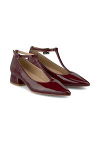 Scarpe a tacco basso in pelle laccata color borgogna, con punta appuntita, design a T-strap e decorazioni sulla cinghia. Texture liscia.