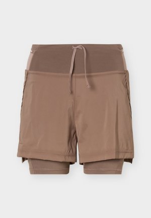 Pantaloni sport scurți maro, în straturi, cu talie elastică și șnur de ajustare, având pe dedesubt pantaloni compresivi și o dungă exterioară mai lejeră.