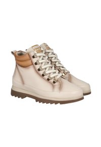 Zapatillas altas beige con cuellos acolchados marrones, cordones blancos pasados por ojales de metal dorado, y suelas de goma marrón estriadas.
