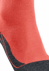 Czerwono-czarna skarpetka o prążkowanej fakturze z kontrastującym czarnym noskiem i piętą. Wzór zawiera widoczne akcenty przeszyć.