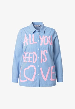 Blå og hvidstribet skjorte med lange ærmer, der har stor pink tekst, som læser "ALT HVA DU BEHØVER ER KÆRLIGHED" på forsiden.