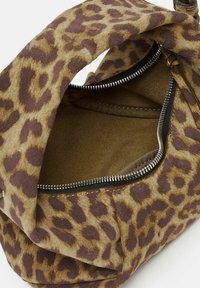 Sac à main en imprimé léopard, doté d'un extérieur doux et texturé, d'une fermeture éclair et d'une finition semblable à du daim. L'intérieur est doublé et lisse.