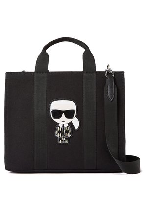 Zwarte rechthoekige draagtas met twee handvatten, afneembare schouderriem en cartoonpatch van een persoon met zwarte zonnebril en een jasje met patroon.