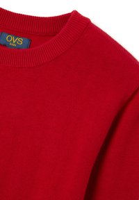 Roter Strickpullover mit geripptem Rundhalsausschnitt und dem "OVS kids" Logo-Tag in Blau und Gelb. Weiche Textur mit glatter Oberfläche.